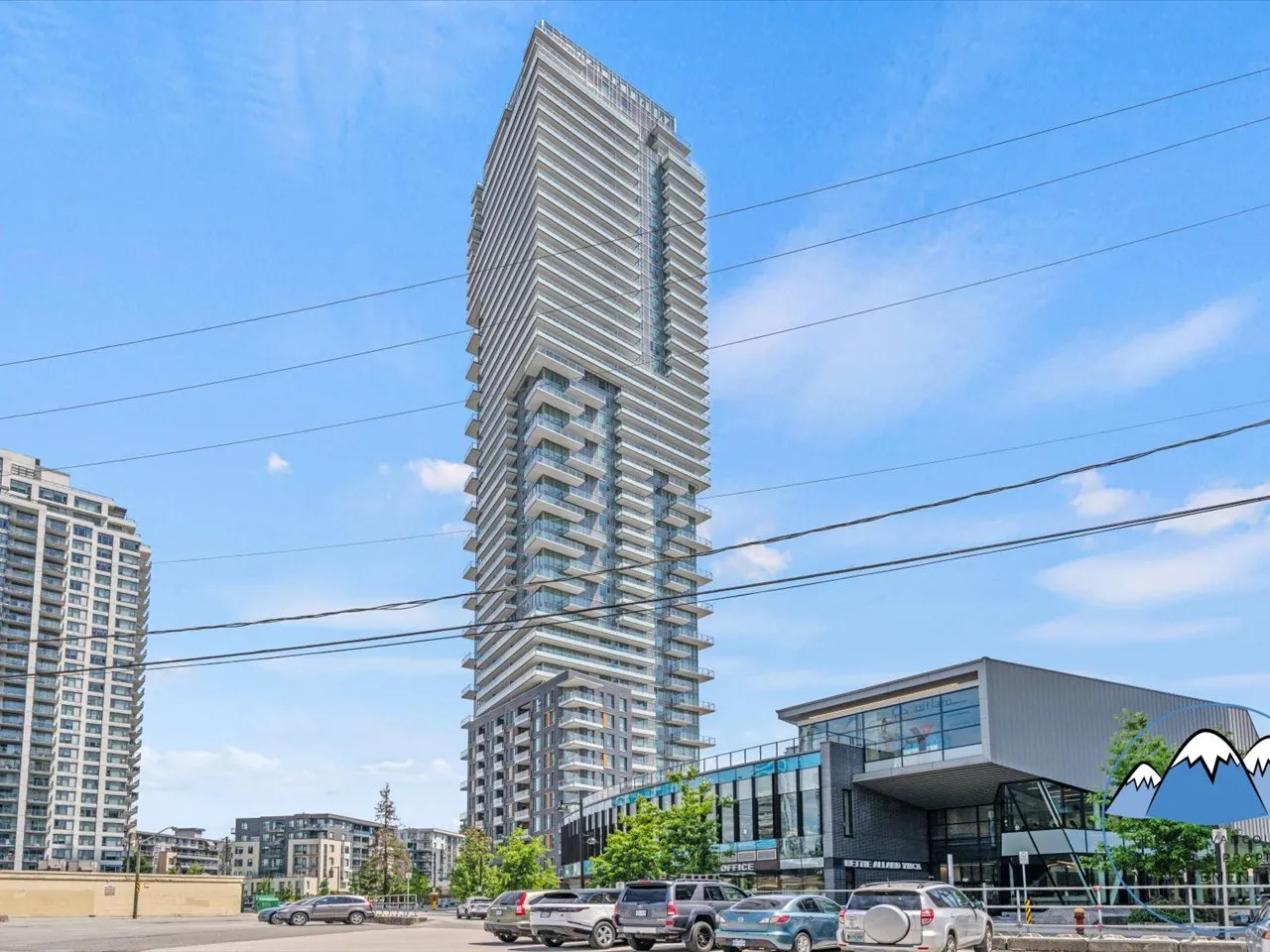 Exterior of the slender Myriad residential tower against a clear blue sky above a retail podium.