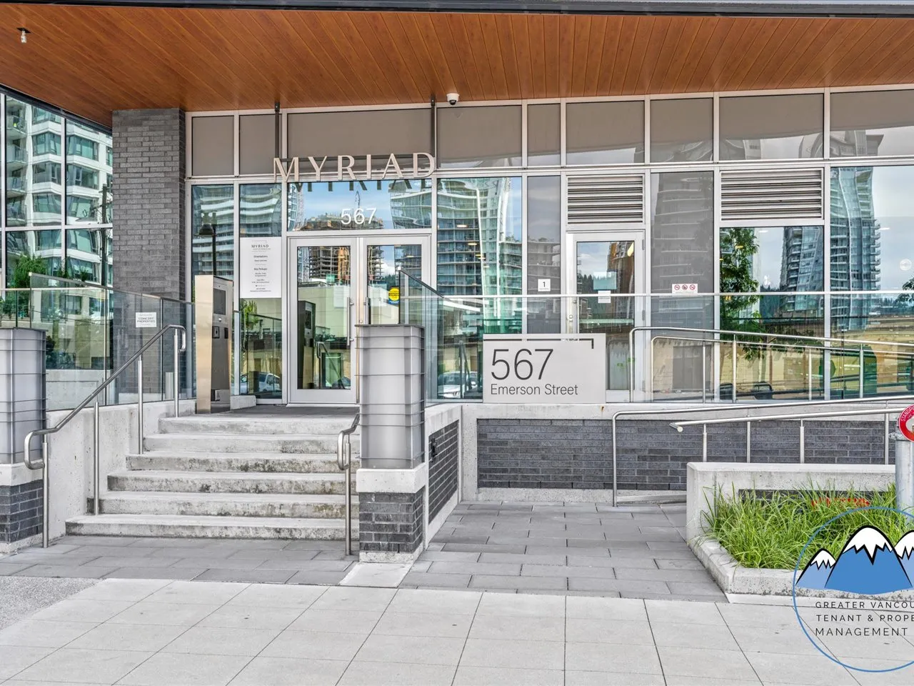 Building entrance with "Myriad 567" lettering, a glass lobby, terraced steps and the 567 Emerson Street address block.