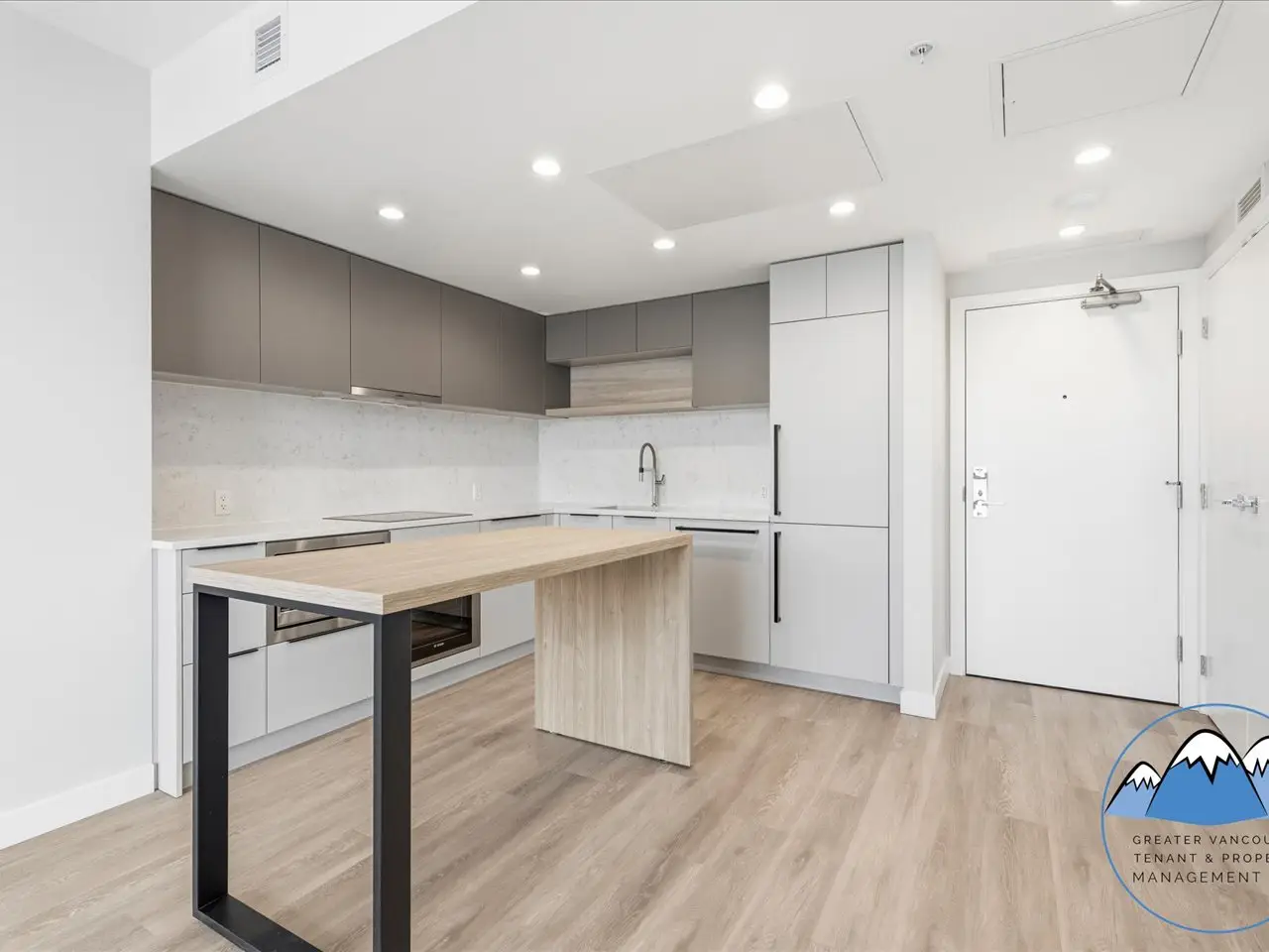 The kitchen with two-tone cabinetry, a marble-look backsplash and integrated appliances.