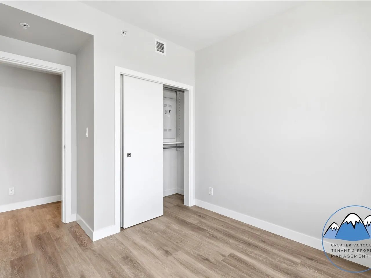 Flexible storage and utility area with a sliding closet door revealing shelving and mechanical storage.