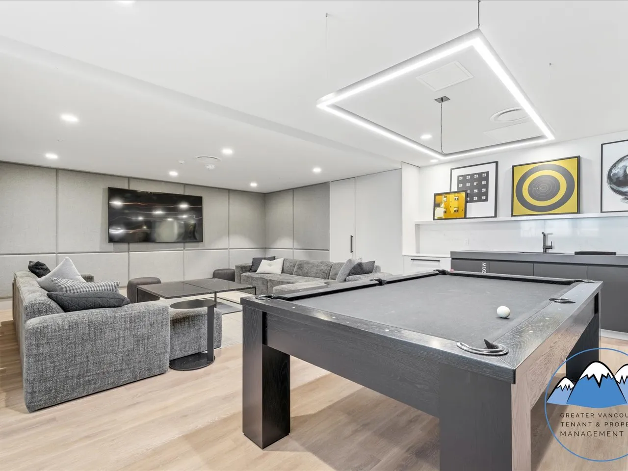 Media and games room with a pool table, lounge seating, a wall-mounted television and a bar counter.