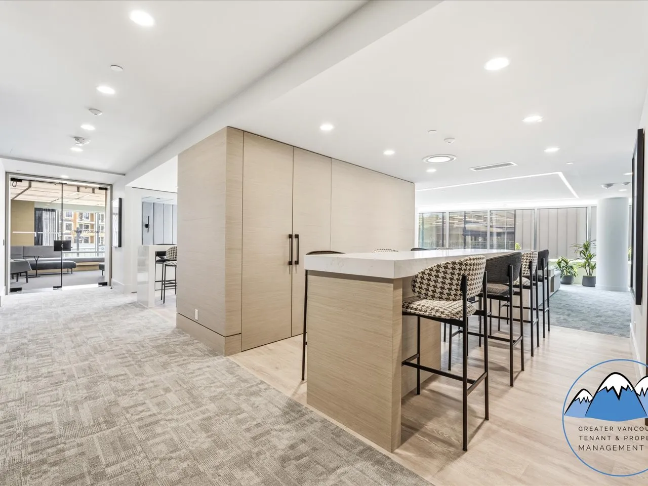 Resident lounge with a communal counter, bar seating and soft seating areas beyond.